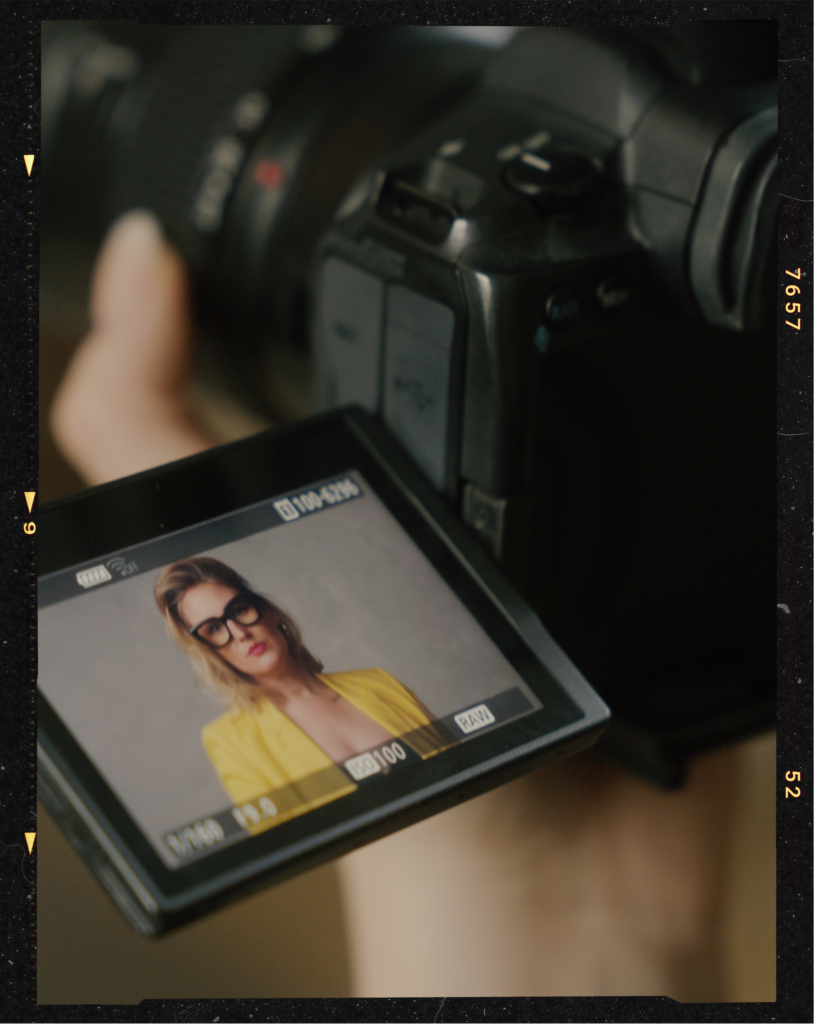 The back of a camera during a portrait shoot of a confident woman in a stockholm portrait studio